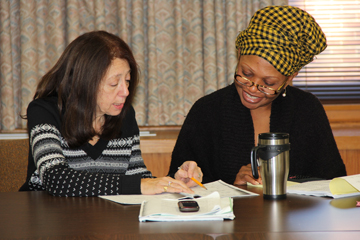 Woman showing another woman something in a book